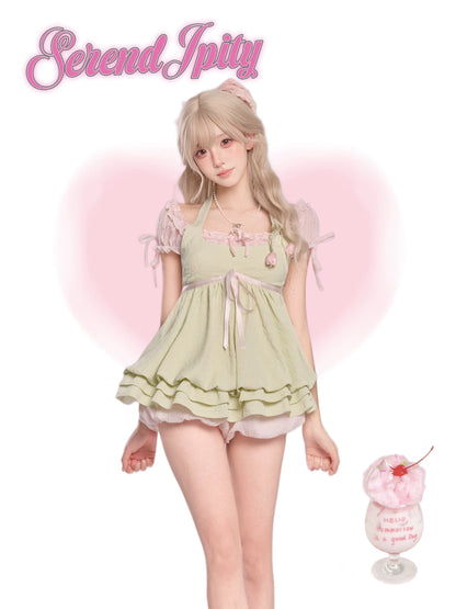 Person wearing a light green lace dress, standing next to a pink dessert.