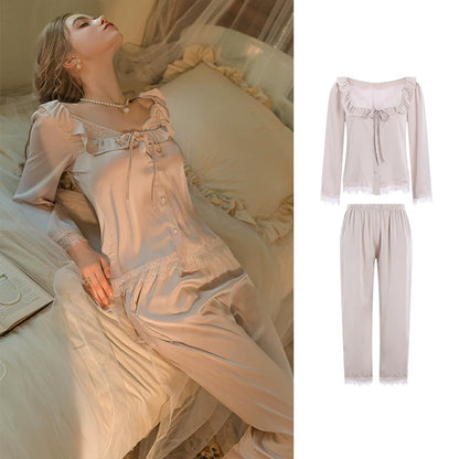 A women's two-piece sleepwear set shown on a model lying on a bed, with a separate inset on the right showing the top and pants laid out against a white background. The set appears in a soft blush pink or pale peach satin-like fabric with ruffled trim, lace details, and long sleeves.