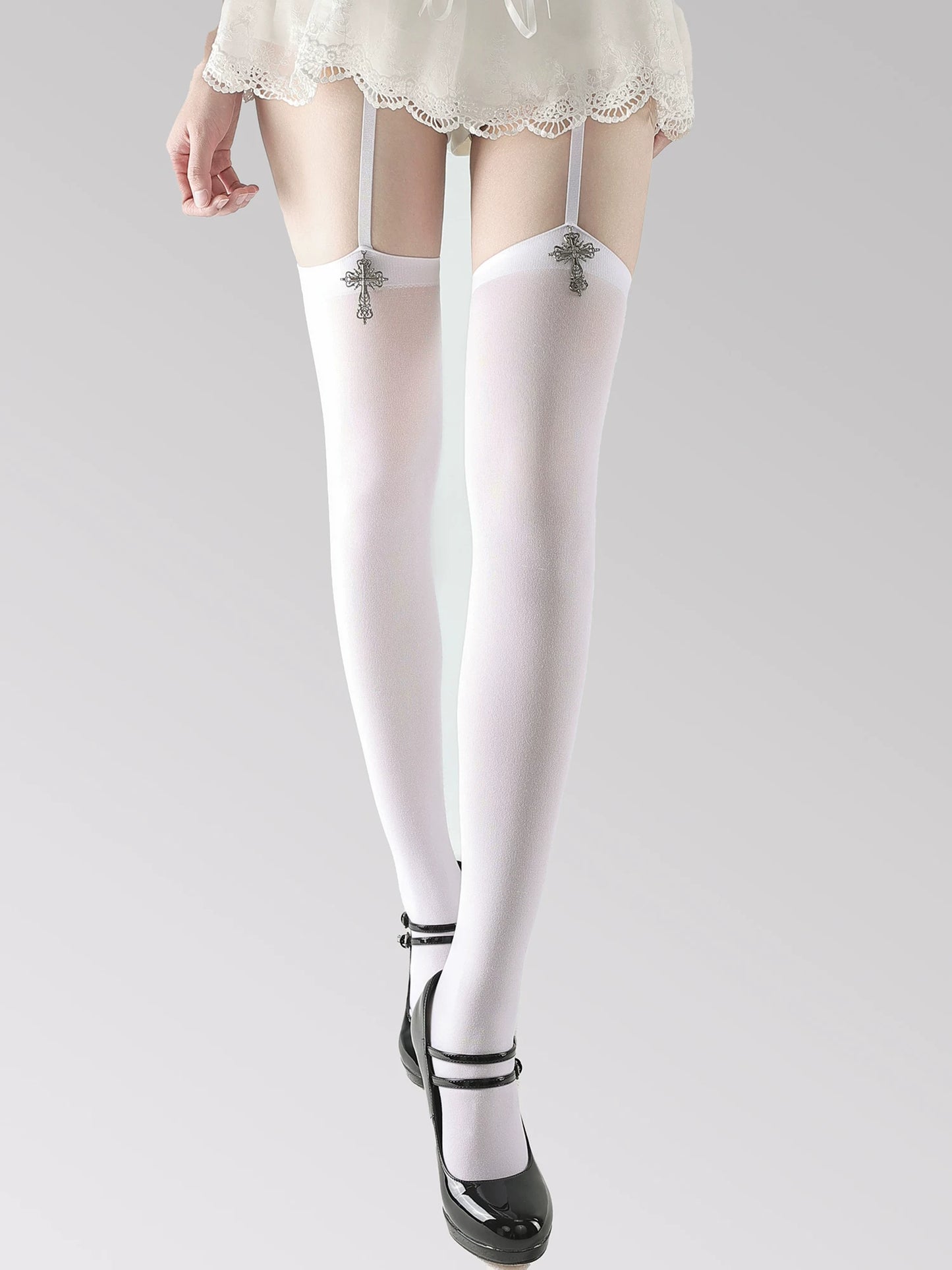 White stockings with black straps worn by a person on a plain background