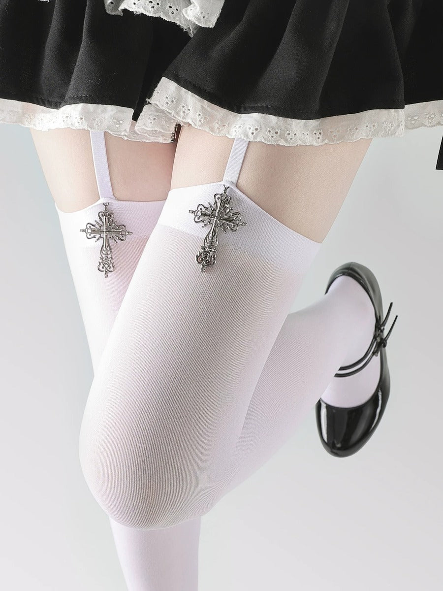 White stockings with decorative cross pins worn by a person, on a plain background.
