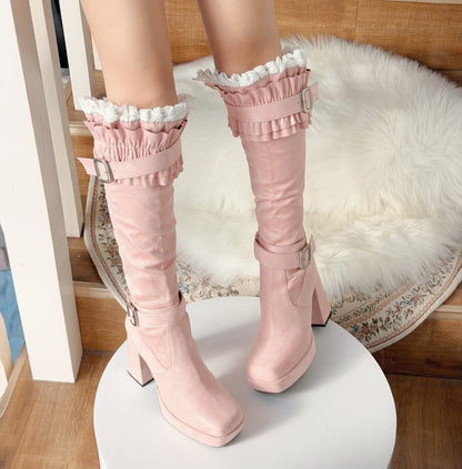 Pink knee-high boots with ruffled details on a white platform.