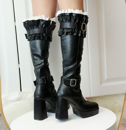 Black knee-high boots with ruffles on a white background
