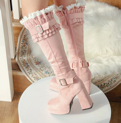 Pink knee-high boots with ruffles on a white platform