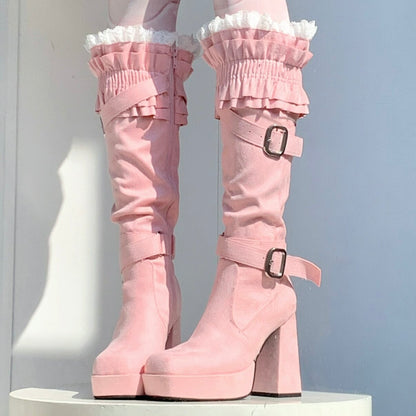 Pink platform boots with ruffled details on a white background