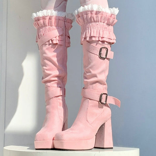 Pink platform boots with ruffled details on a white background