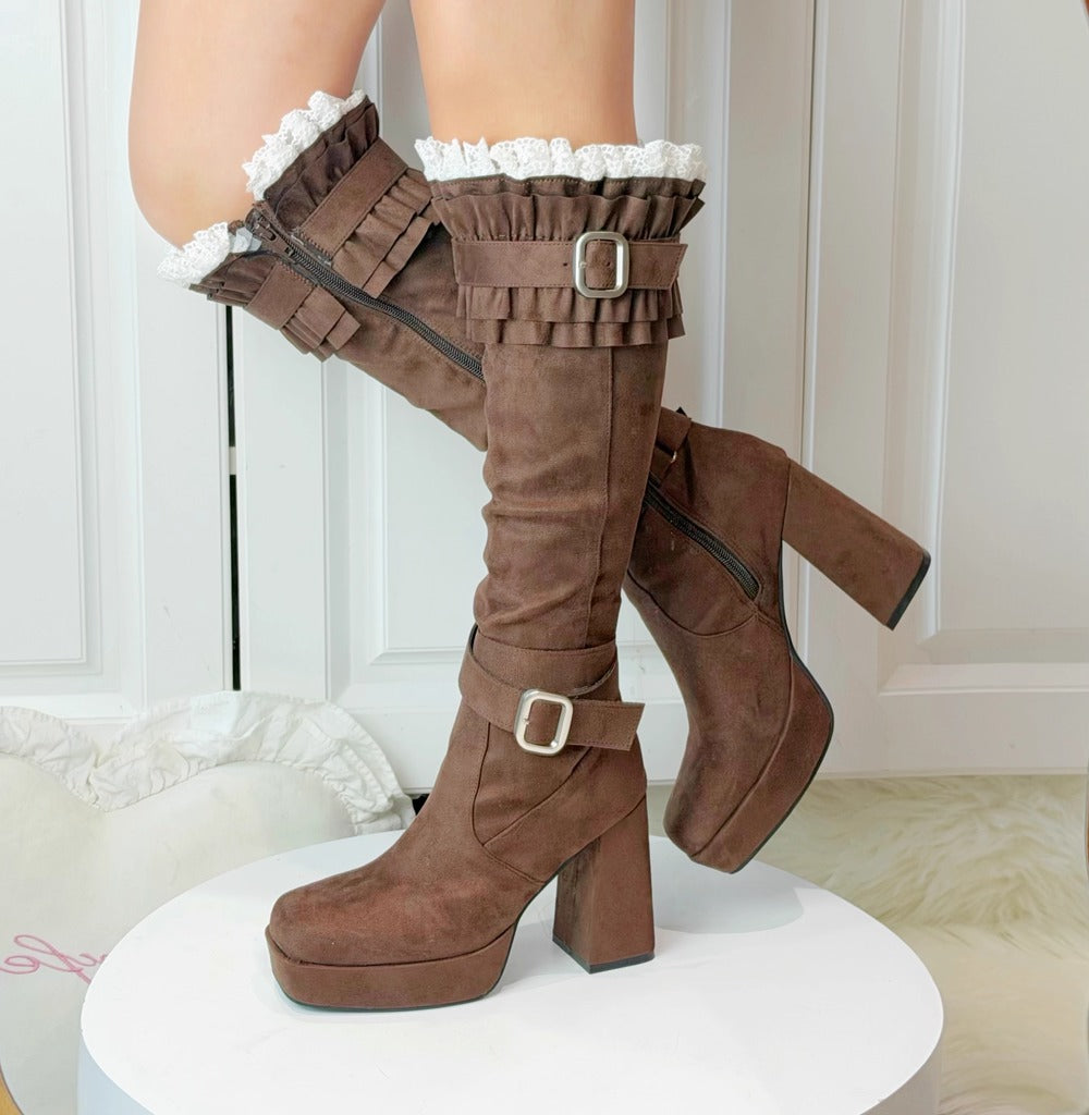 Brown knee-high boots with lace details on a white background
