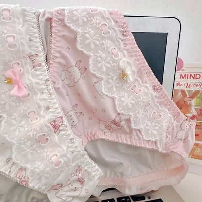 Pink lace underwear with bunny designs on a white surface.