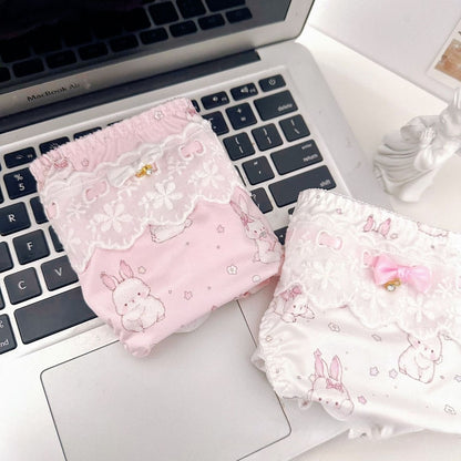 Two pink and white patterned pouches on a laptop keyboard