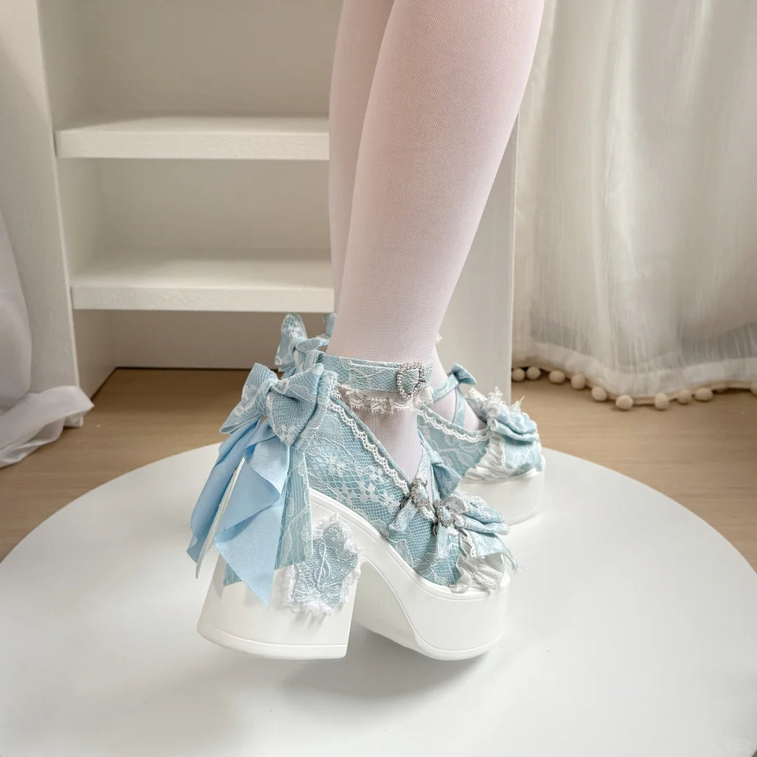 Light blue lace-up shoes with bows worn by a person on a white platform.