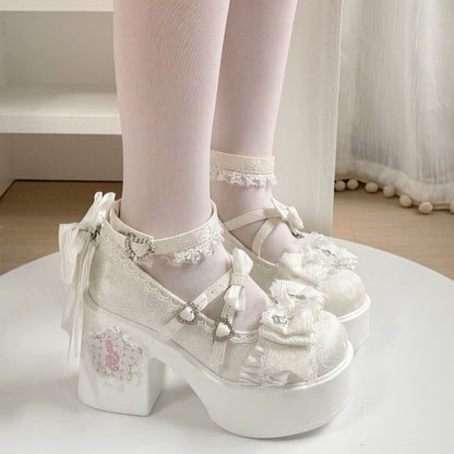 White platform shoes with decorative elements worn by a person on a white surface.