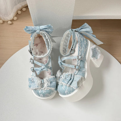 Pair of light blue lace-up shoes with decorative bows on a white platform.