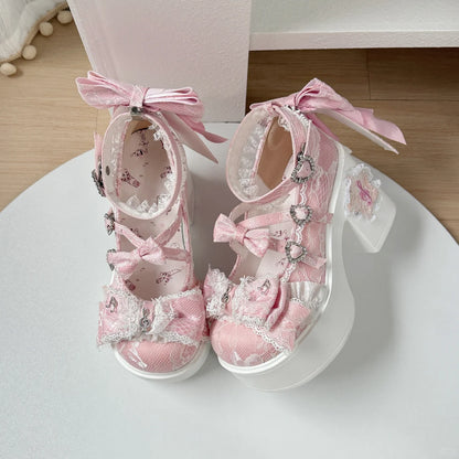 Pink decorative shoes with bows on a white surface