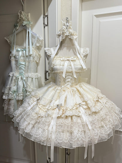 Two dresses on mannequins with intricate designs and ruffles in a neutral setting.
