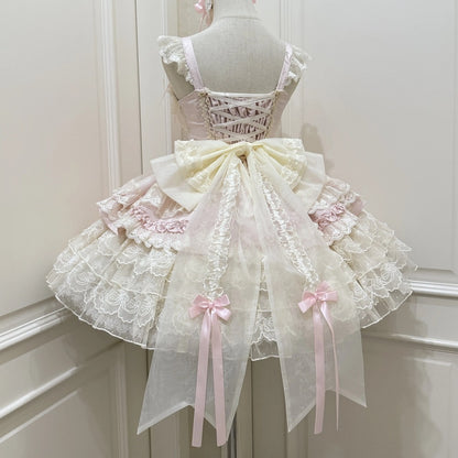 Delicate lace dress with pink ribbons on a mannequin against a white background
