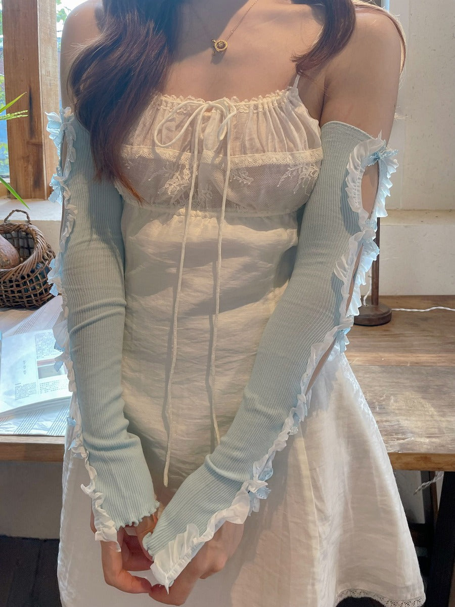 Person wearing a light blue dress with lace details indoors.