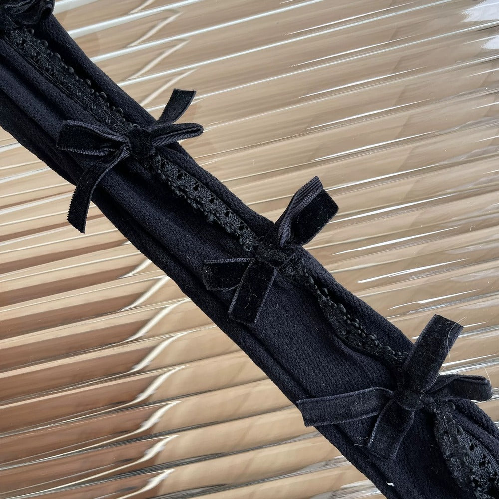Black lace trim with small bows on a textured beige background