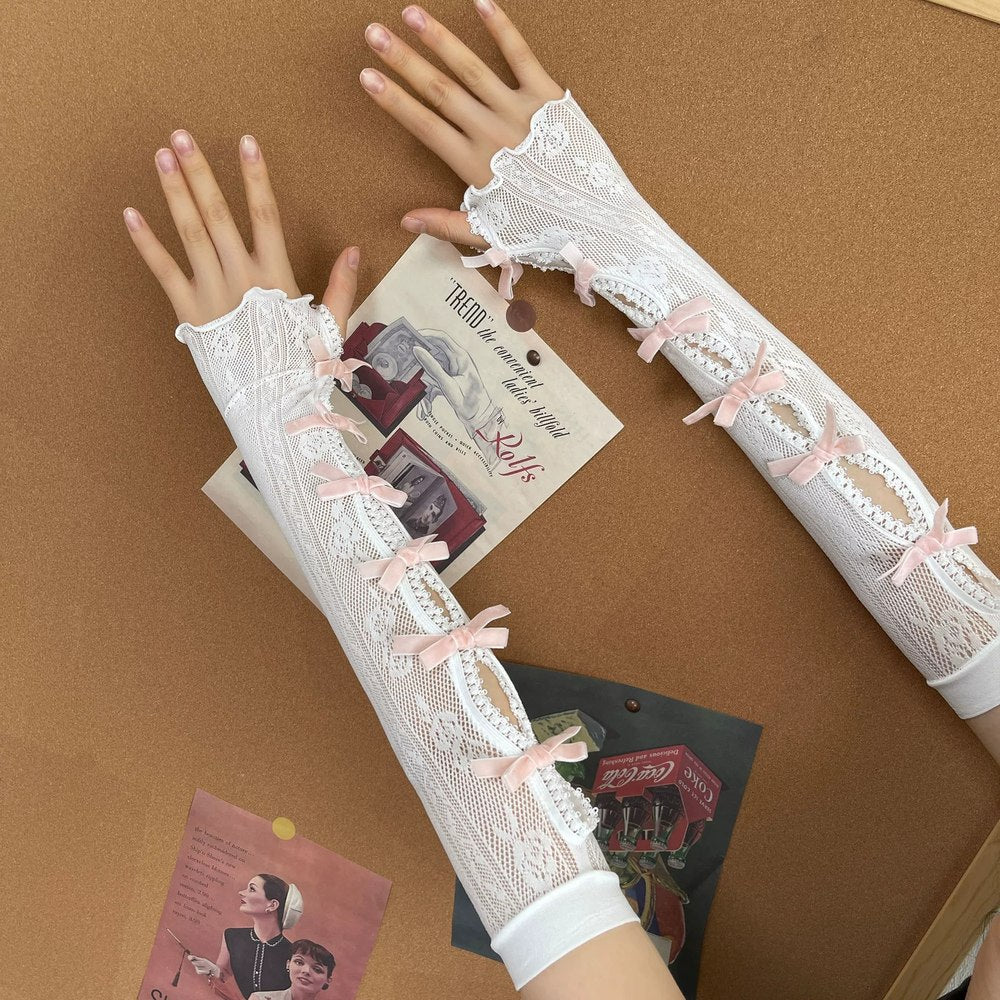 White lace gloves with pink bows on a brown background