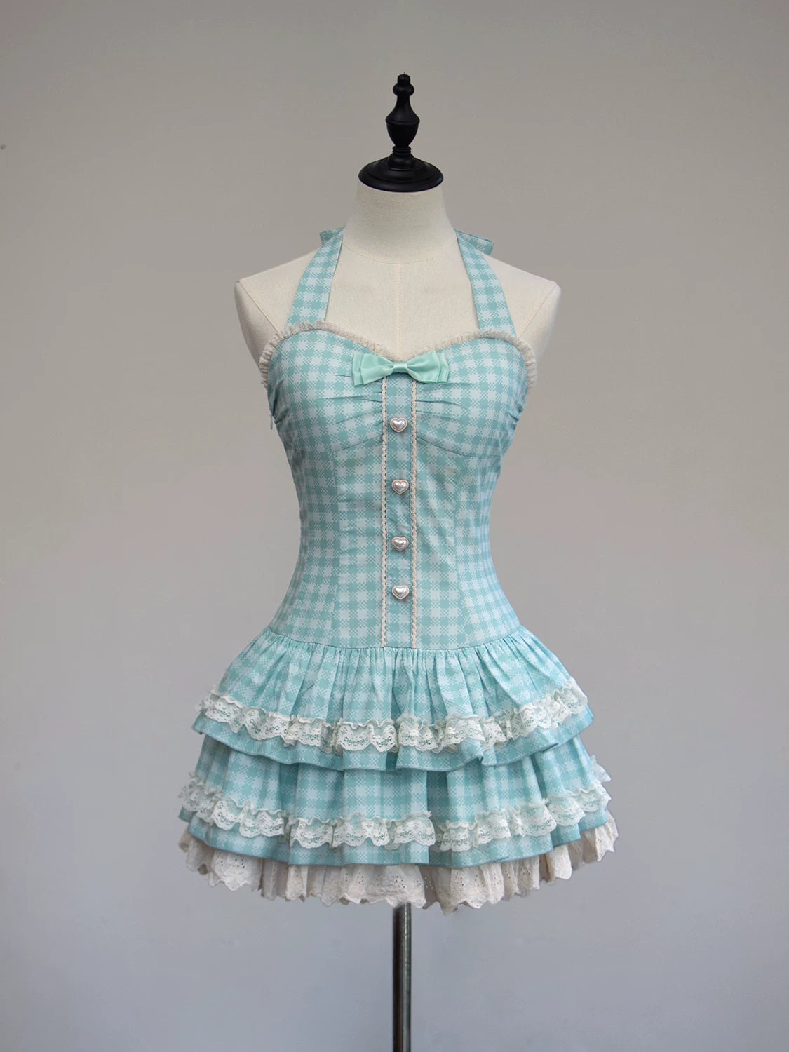 Light blue checkered dress with white lace details on a mannequin against a gray background
