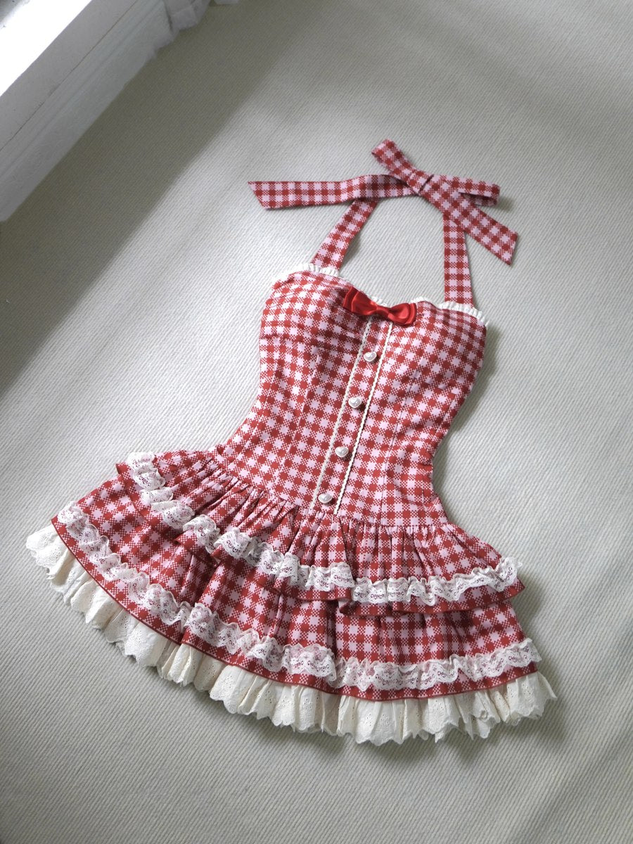 Red and white checkered dress with ruffles on a gray surface