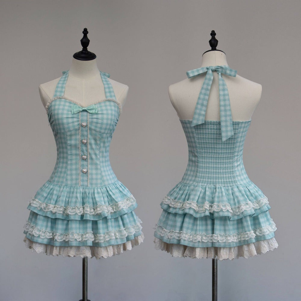 Light blue checkered dress with ruffled layers on mannequins against a gray background