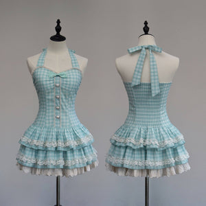 Light blue checkered dress with ruffled layers on mannequins against a gray background