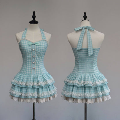 Light blue checkered dress with ruffled layers on mannequins against a gray background