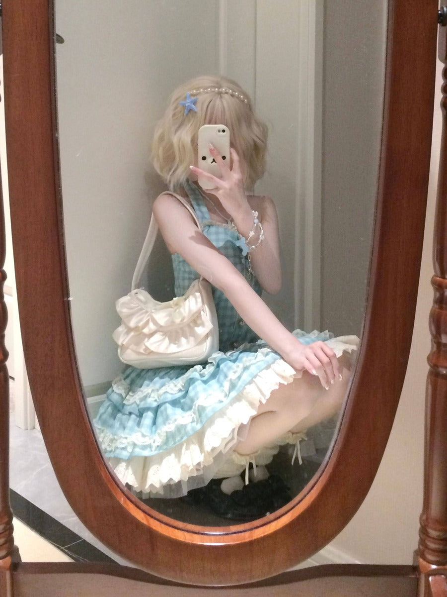 Person in a light blue and white dress sitting in front of a mirror with a wooden frame.