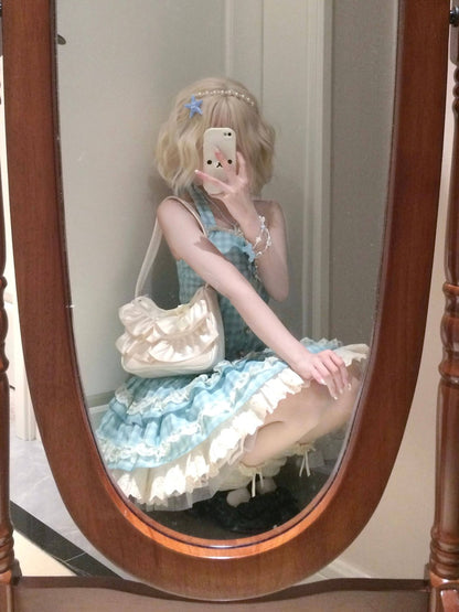 Person in a light blue and white dress sitting in front of a mirror with a wooden frame.