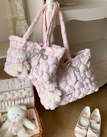 A pair of light pink quilted puffer tote bags with matching shoulder straps, decorated with small plush teddy bear charms and silver rhinestone bows, displayed in a soft, pastel-themed room setting.
