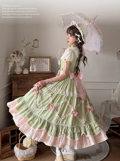 Woman in a green and pink Lolita dress with an umbrella in a room setting.