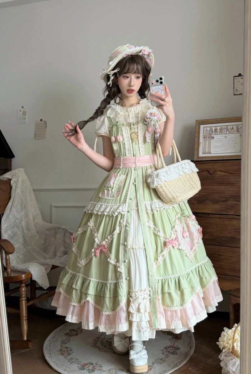Person wearing a light green and pink dress with floral details, taking a mirror selfie.