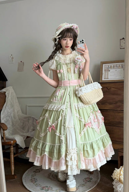 Person wearing a light green and pink dress with floral details, taking a mirror selfie.