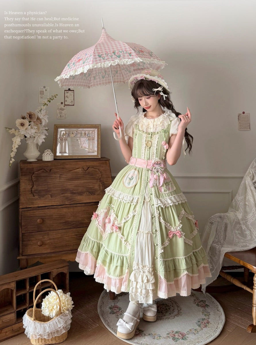 Woman in a green and pink Lolita dress holding an umbrella in a room with wooden furniture and decorative items.