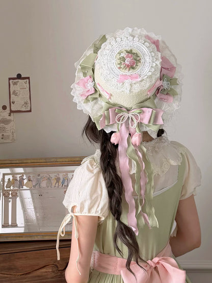 Person wearing a decorative bonnet with floral and lace details in a room setting.