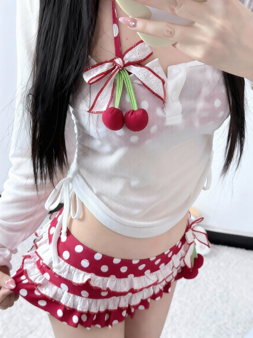 Person wearing a white polka dot outfit with red cherries and ruffles.