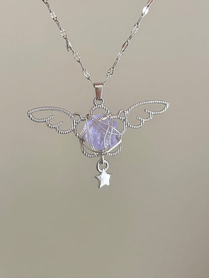 Silver pendant with a star charm on a beige background