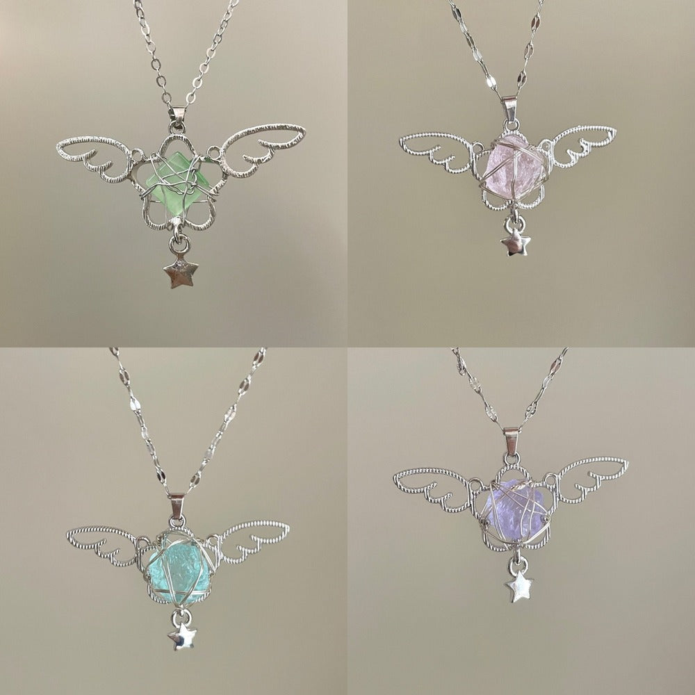 Four angel wing pendants with gemstones on a neutral background