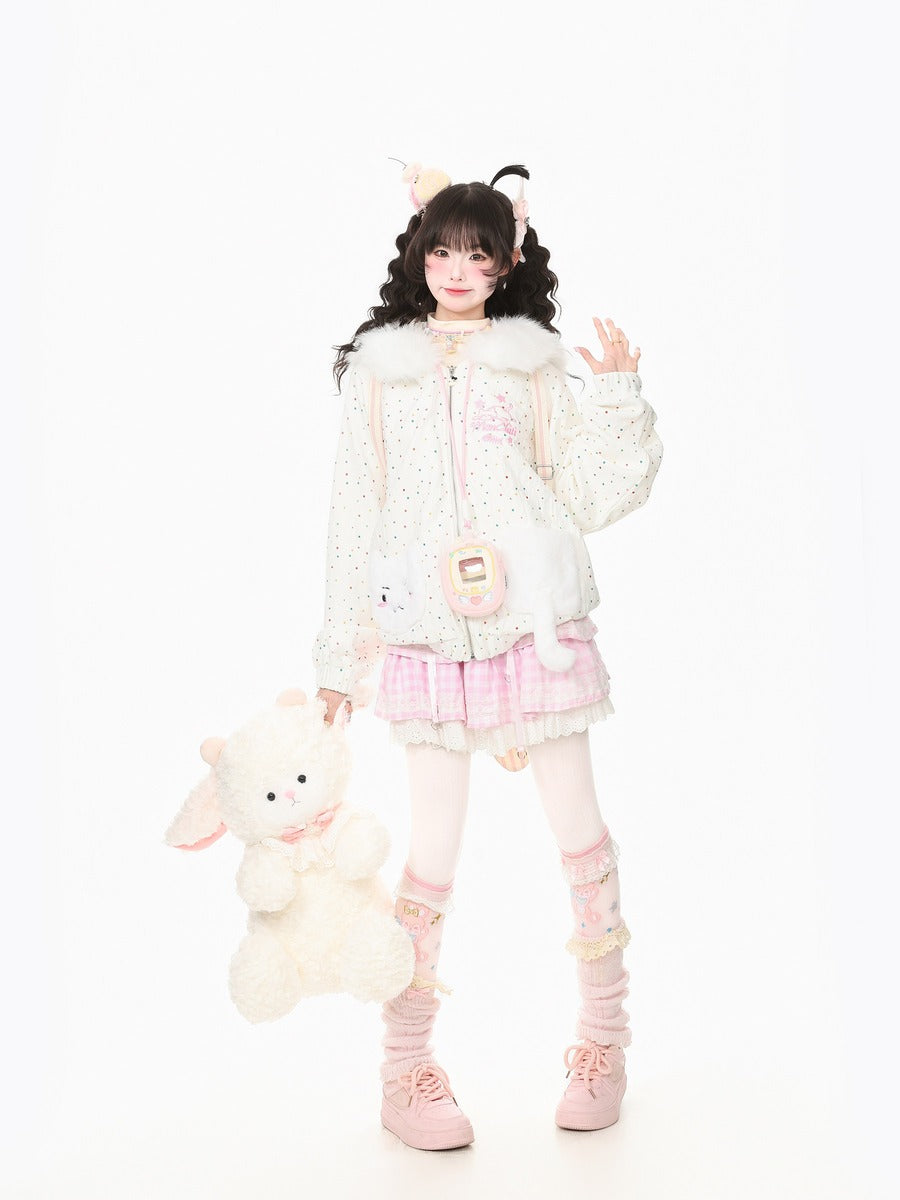 A young girl models a cute, pastel-themed outfit consisting of a white dotted jacket with faux fur trim, a pink plaid pleated skirt, pink knee-high socks, and pink sneakers. She is holding a plush white stuffed bunny against a seamless white studio background.