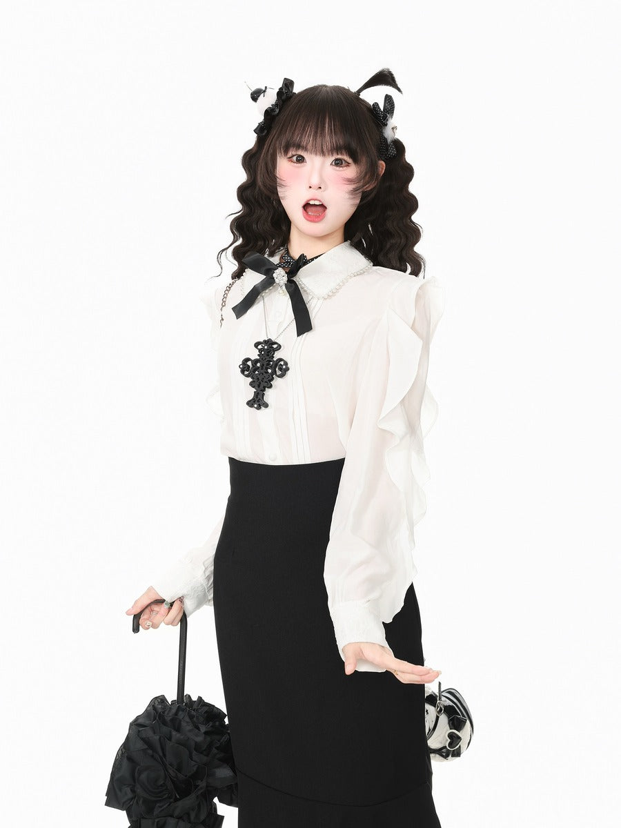 A model posing in a white long-sleeve blouse with black lace trim, a black cross applique, and a black skirt, holding a black flower-shaped umbrella against a plain white background.