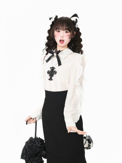 A model posing in a white long-sleeve blouse with black lace trim, a black cross applique, and a black skirt, holding a black flower-shaped umbrella against a plain white background.