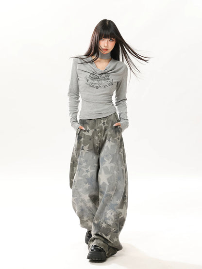 Woman wearing a gray long-sleeve top and camouflage pants on a white background