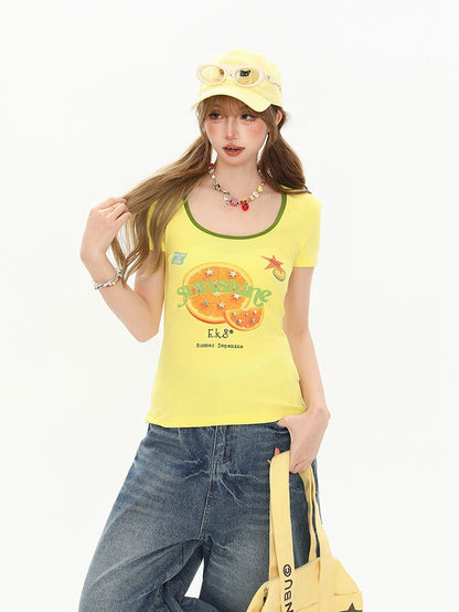 Woman wearing a yellow tank top with a graphic design, blue jeans, and a yellow cap on a white background.