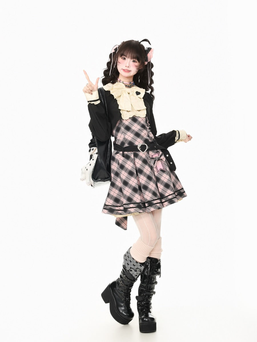 A model posing in a Lolita-style outfit featuring a pink and black plaid pleated dress with a cream bow collar, a black jacket, and black lace-up boots, set against a plain white background.