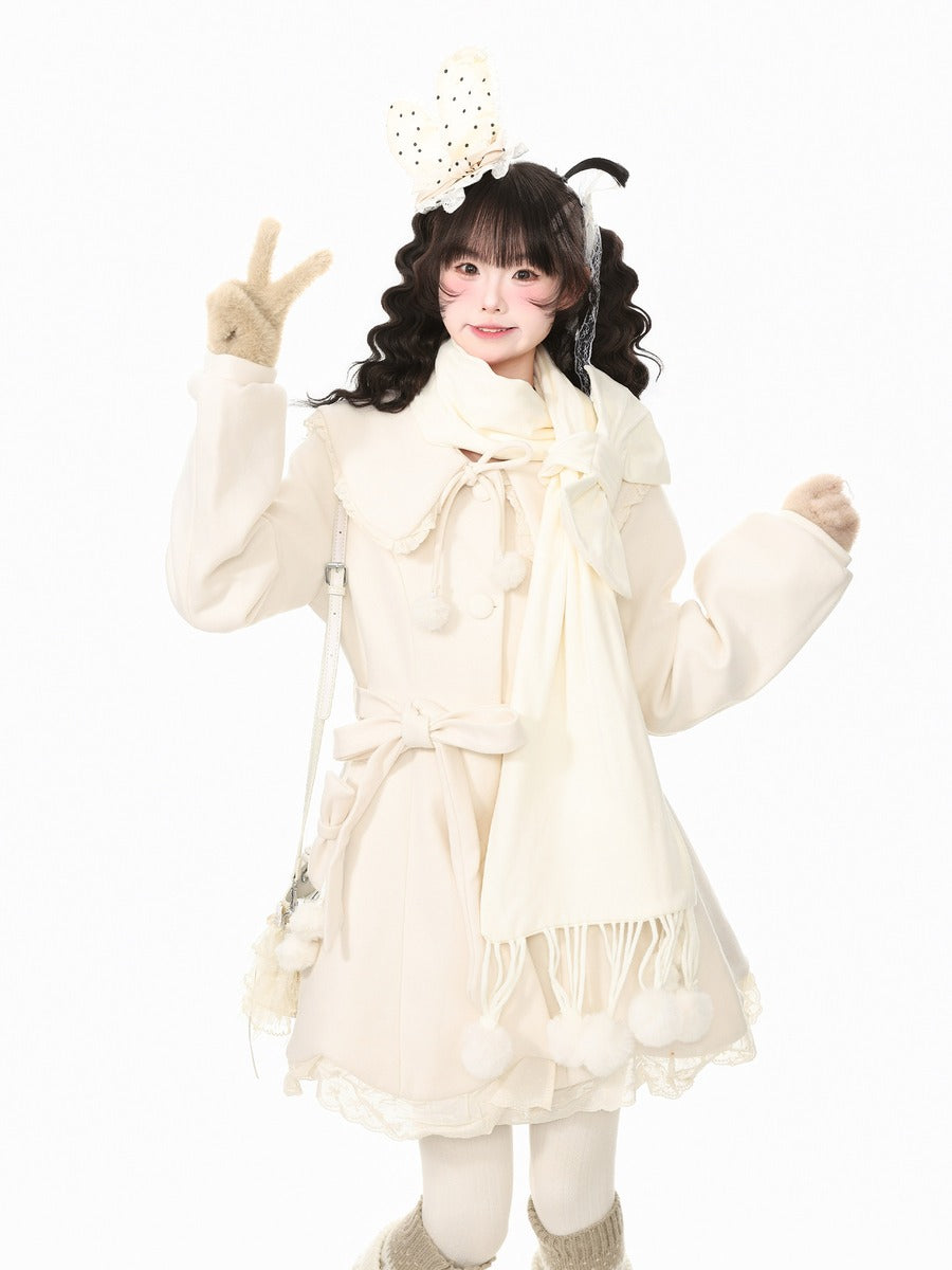 A young girl with dark curly hair wearing a cream-colored winter outfit, including a long-sleeve coat, matching scarf, gloves, and a decorative headband, posing against a solid white background.