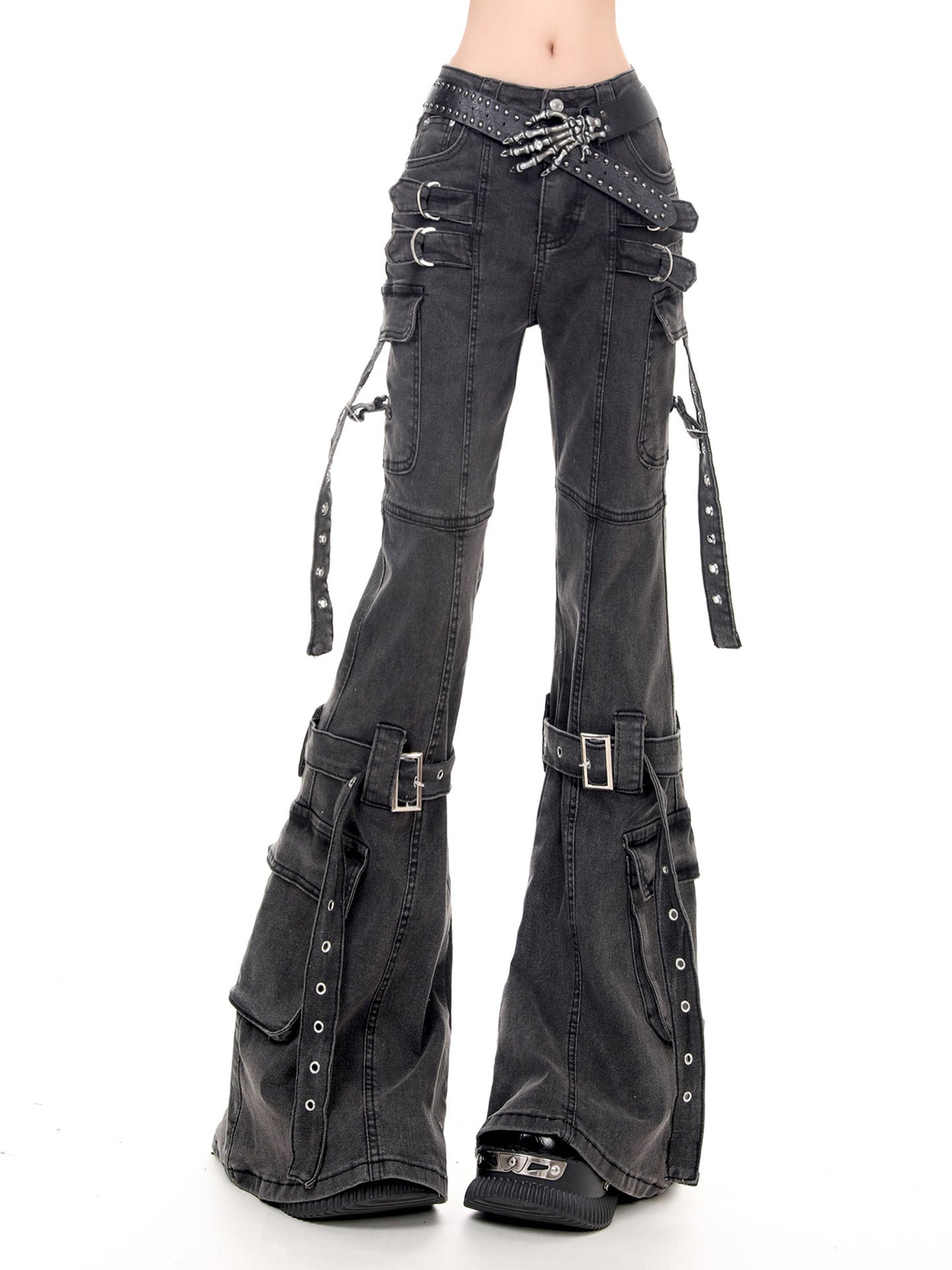 Black washed denim flare pants with multiple utility pockets, buckle straps, and studded details, shown on a model against a white background.