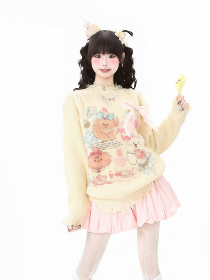 A young woman modeling a cream-colored fuzzy sweater with a colorful cartoon bear graphic, paired with a light pink pleated skirt, against a solid white background.