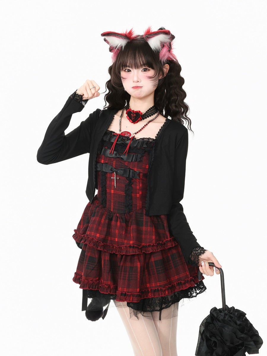A model wearing a gothic Lolita-style outfit consisting of a red and black plaid corset dress, a black cardigan, a red rose choker, and pink and white fox ears headband, holding a black ruffled umbrella against a white background.