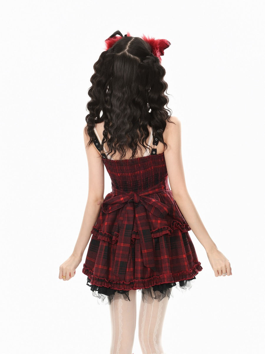 A girl shown from the back wearing a red and black plaid strapless dress with a ruffled tiered skirt and a matching red and black plaid hair accessory with fluffy red ends, against a plain white background.