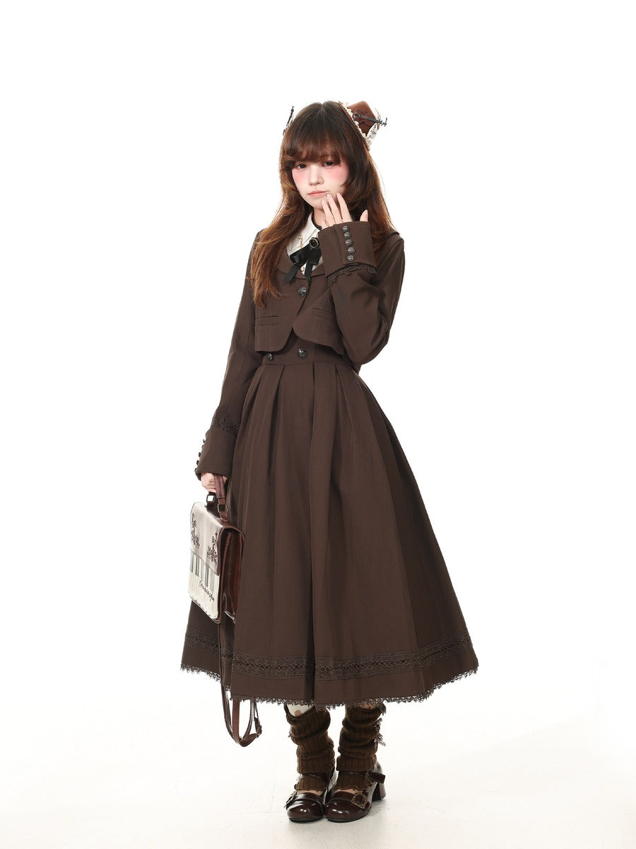A model wearing a dark brown Victorian-style Lolita dress with a matching jacket, holding a small vintage-style handbag against a solid white background.