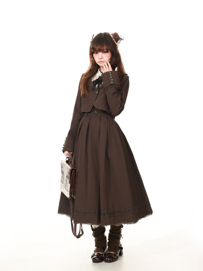 A model wearing a dark brown Victorian-style Lolita dress with a matching jacket, holding a small vintage-style handbag against a solid white background.